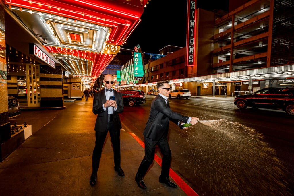 grooms celebrating with champagne after their fun elopement ceremony