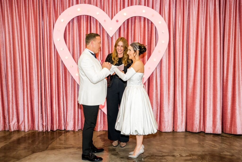 cute picture of the bride and groom holding hands during their ceremony