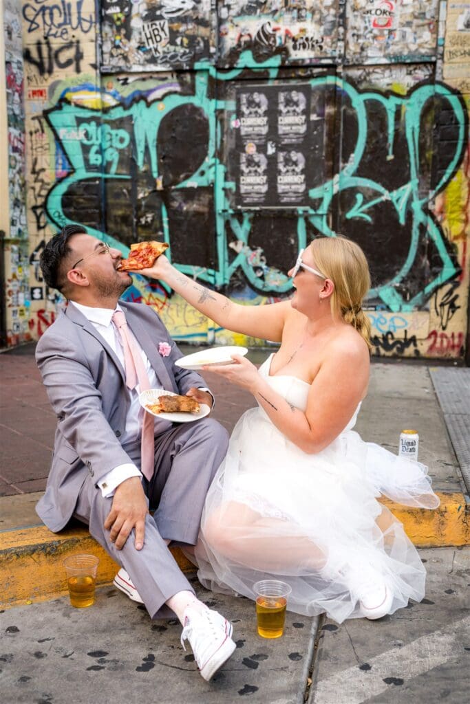 newly married couple celebrating their elopement with pizza