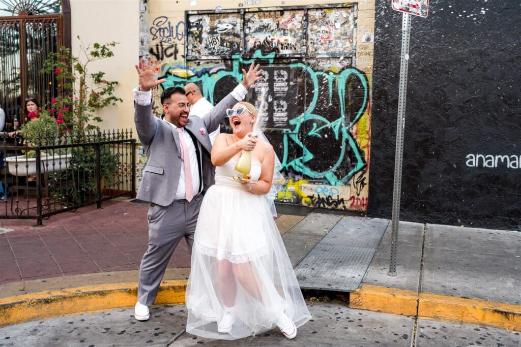 newly married couple celebrating their elopement with champagne