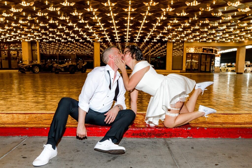 portrait of the newly eloped couple kissing in downtown fremont street 