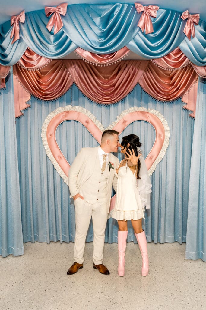 Picture of a newly married, couple kissing and showing their wedding rings